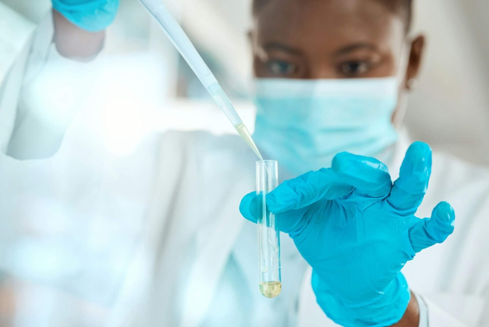 Shot of a young scientist sitting alone in her laboratory and testing urine