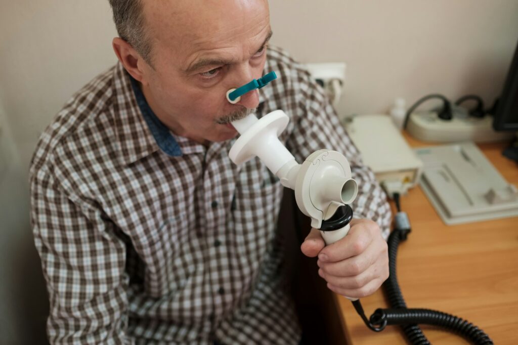 Senior hispanic man man testing breathing function by spirometry