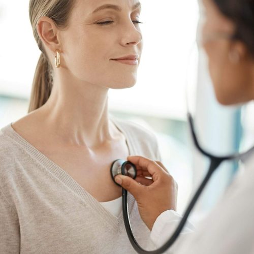 Checking and hearing heart rate with a working doctor consulting the wellness and health of a woman