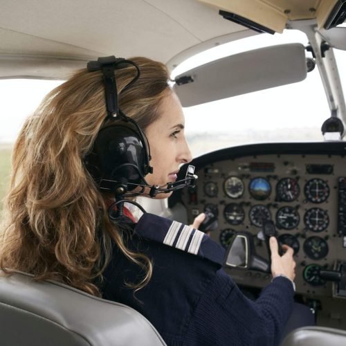 Female pilot in the cockpit of an airplane.